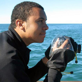 researcher with a camera looking out to the ocean