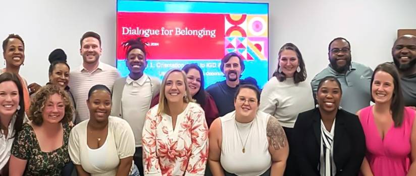 Photo of 18 staff members from cohort 1 standing together smiling