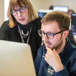 Person being mentored/advised while working on a computer