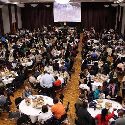 A large group of people sitting at banque tables.