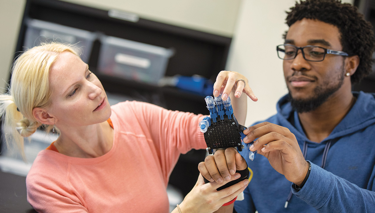 Students testing a mechanical hand.