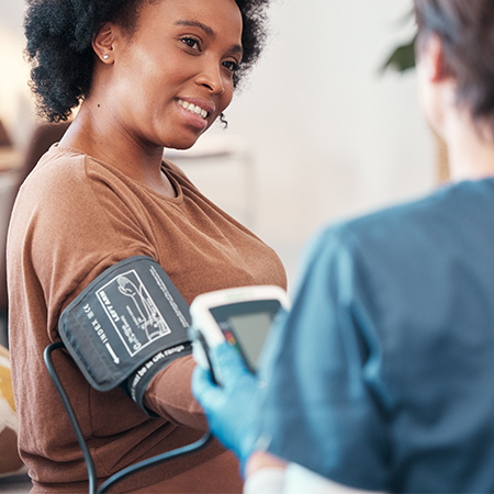 Someone taking a patient's blood pressure reading.