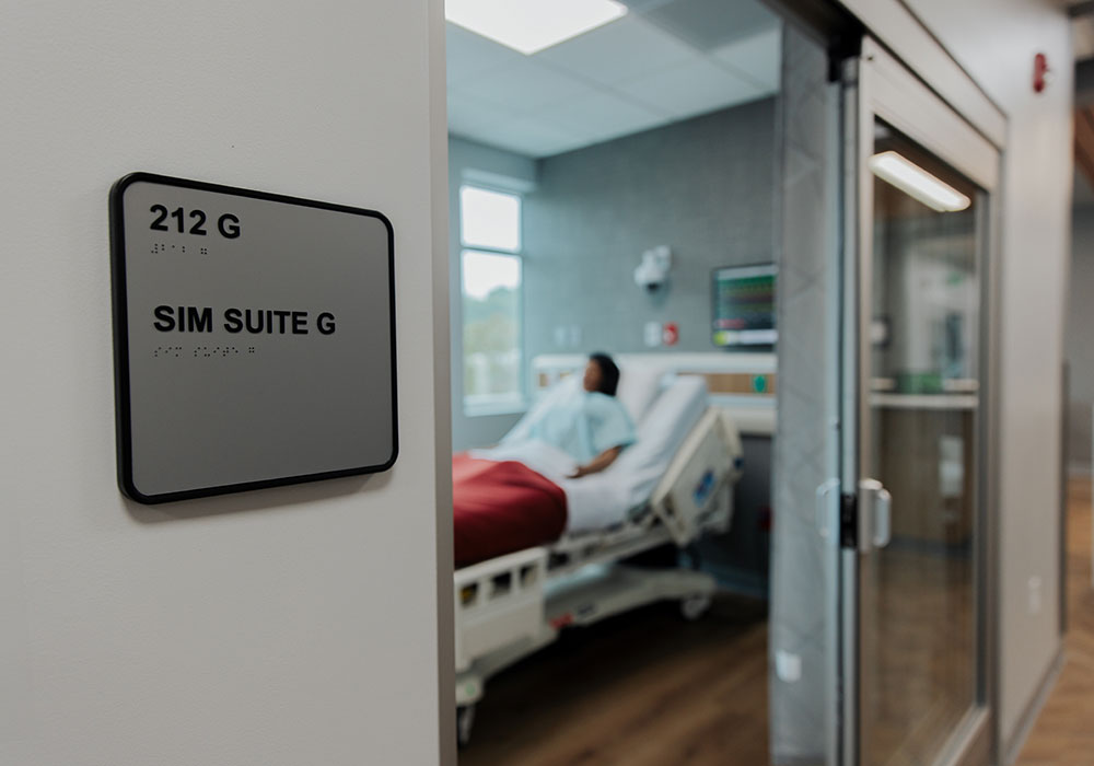 Entrance to clinical training suite with a simulated patient in bed  