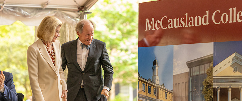 Peter and Bonnie McCausland stand beside a new McCausland College of Arts and Sciences display on the University of South Carolina Horseshoe during the naming ceremony.