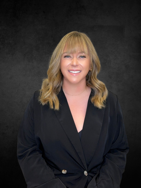 woman smiling outside with paid jacket on