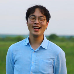 man standing outside with a light blue shirt on smiling