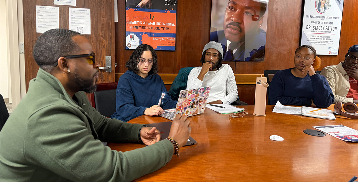 Jabari Evans sitting at a table with students