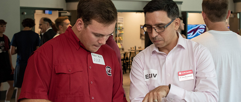 Dr. Caicedo looks at a paper with a student