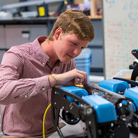 hunter damron works on a robot