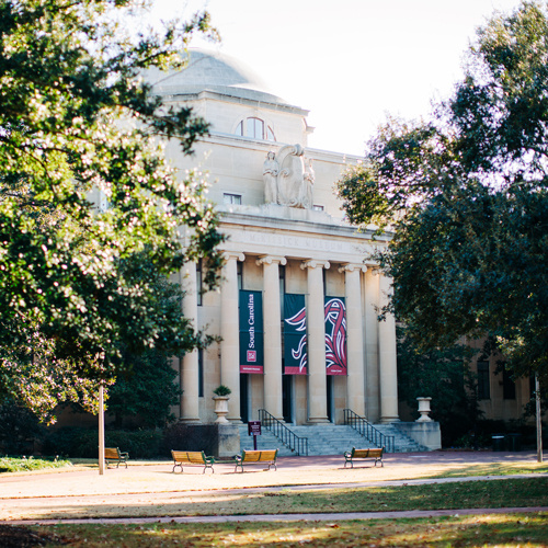 A grand light colored building with tall columns.