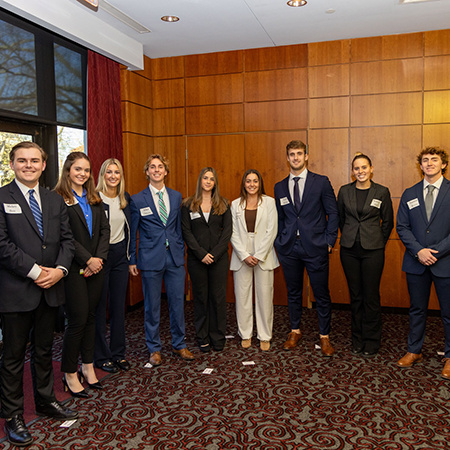 Students pose for a photo wearing professional attire.