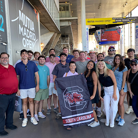 Students pose for a photo while visiting a tennis venue in Madrid, Spain.