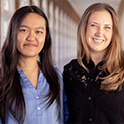 Two students posing in a hallway
