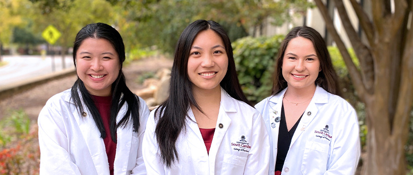 Three students in white coats