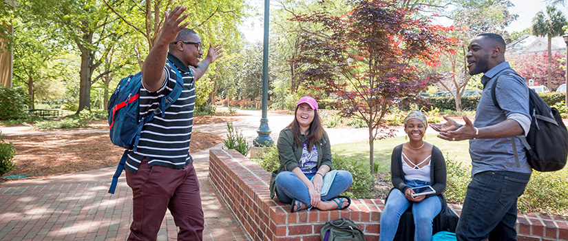 Students hanging out in front of the entrance to Hamilton College