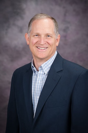 man in blue blazer smiling