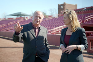 two people stand in a baseball stadium