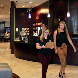 Students and alumni working at hotel, people dining in background