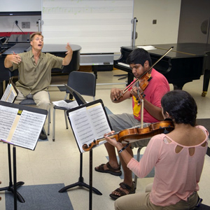 students sit in a circle and play instruments