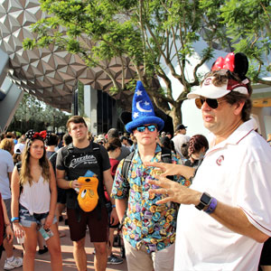 Man talks to group of student at a theme park