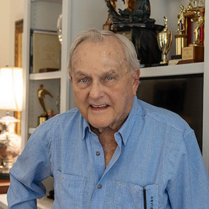 Humpy Wheeler stands in front of his bookshelves