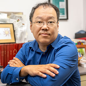 Ken Shimizu sits at his desk