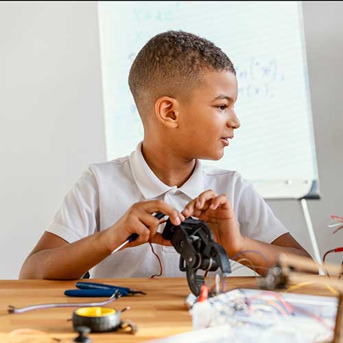 Boy builds robot at table