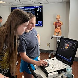 Two young women looking at an ultrasound on a monitor 