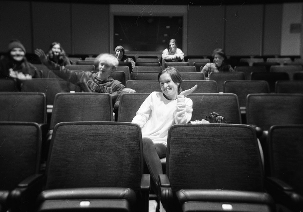 a black and white photo of people sitting in a theater
